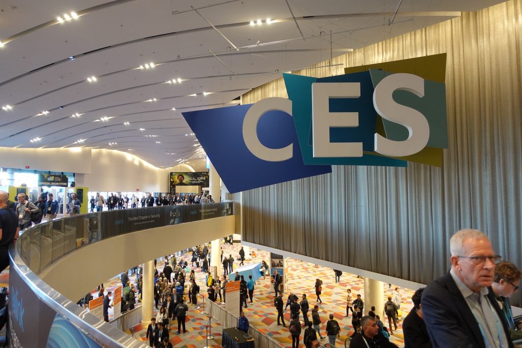 blue CES sign with white lettering above people standing